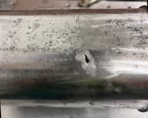 A photo of the air filter housing showing a small hole, presumably from a cut-off wheel.