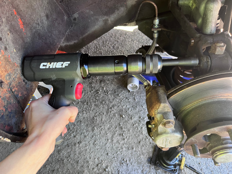 A photo showing a Harbor Freight Chief air hammer ever slightly too long to fit in the passenger's side wheel well.