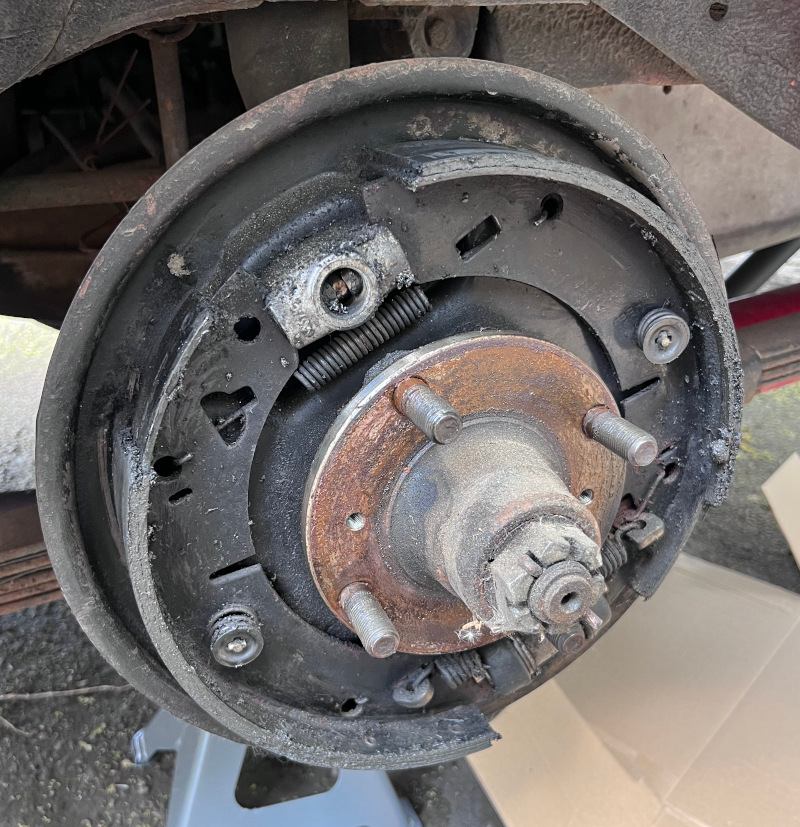 A photo of the rear driver's side drum brakes covered in a mixture of gear oil and dirt.