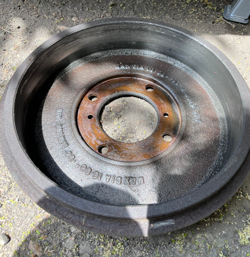 A photo of the inside of the rear driver's side brake drum covered in a mixture of gear oil and dirt.